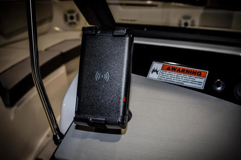 Slide: The Image of Yamaha Boats AR220 2023 model with a wireless phone charger and warning label. - 24