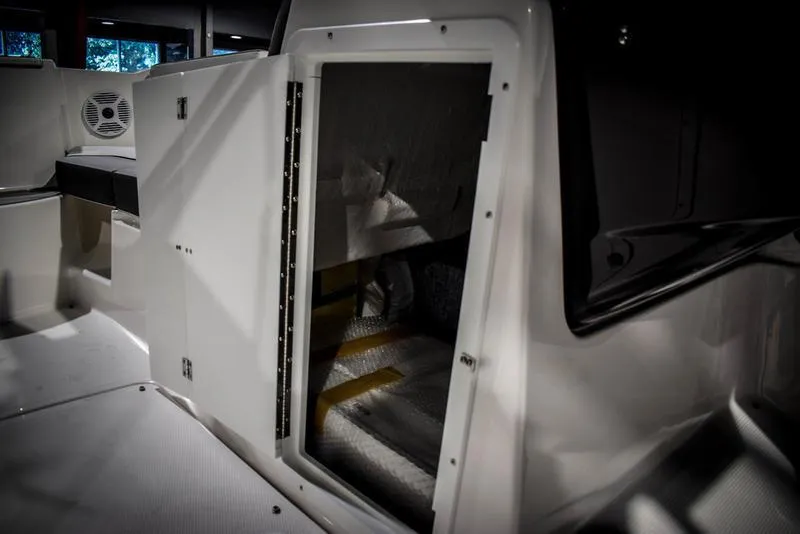 Slide: The Image of 2023 Yamaha Boats AR220 interior storage compartment with open door. - 32