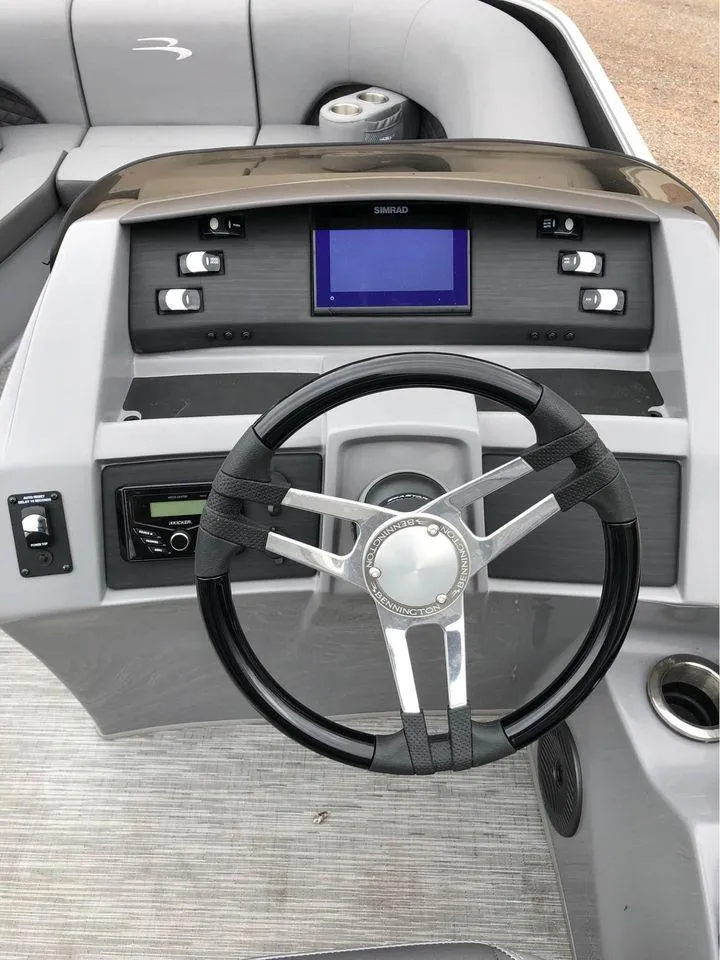 Slide: The Image of 2022 Bennington 24 RTSB boat dashboard with steering wheel and control panel. - 4