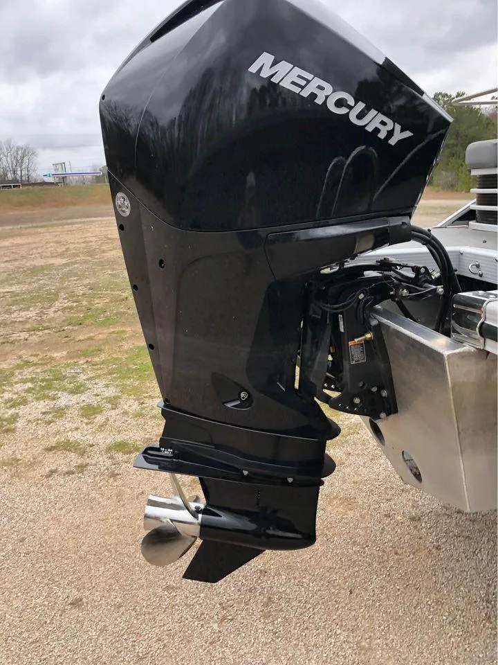 Slide: The Image of 2022 Bennington 24 RTSB with Mercury outboard motor, parked on gravel. - 9