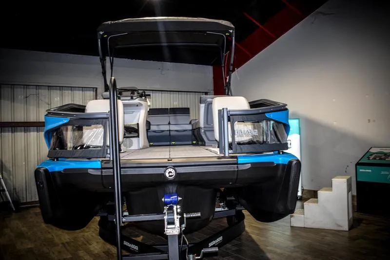 Slide: The Image of 2023 Sea-Doo Switch Sport 21 pontoon boat displayed indoors. - 2