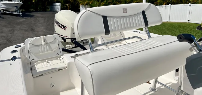Slide: The Image of 2010 Carolina Skiff 198 DLV Elite boat interior with white seating and Evinrude outboard motor. - 10