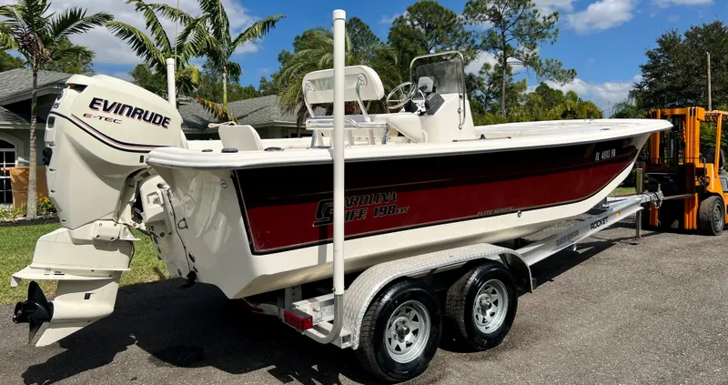 Slide: The Image of 2010 Carolina Skiff 198 DLV Elite boat on trailer with Evinrude outboard motor. - 2