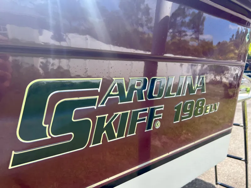 Slide: The Image of 2010 Carolina Skiff 198 DLV Elite boat side view with logo. - 7