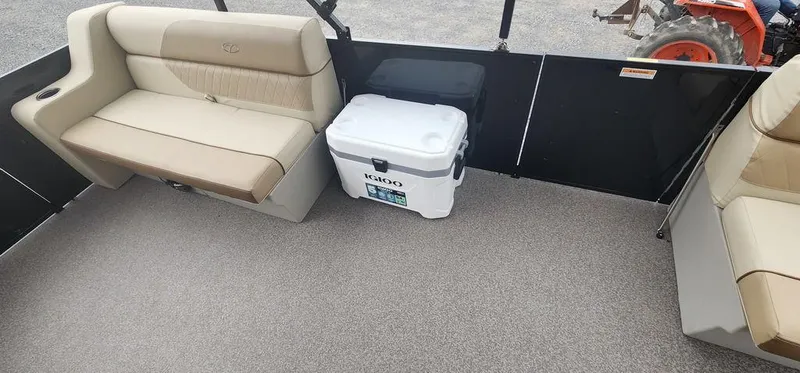 Slide: The Image of 2023 Veranda VISTA20RC Bi-Toon interior with beige seating and a white Igloo cooler. - 23