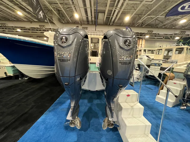 Slide: The Image of 2024 Defiance Admiral 250 EX boat with twin outboard engines at a boat show. - 10