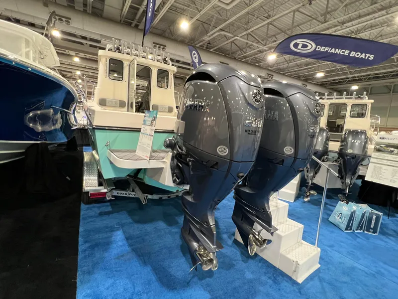 Slide: The Image of 2024 Defiance Admiral 250 EX boat with twin outboard motors at a boat show. - 11