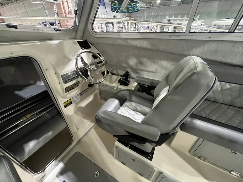 Slide: The Image of 2024 Defiance Admiral 250 EX boat interior with captain's chair and steering console. - 17
