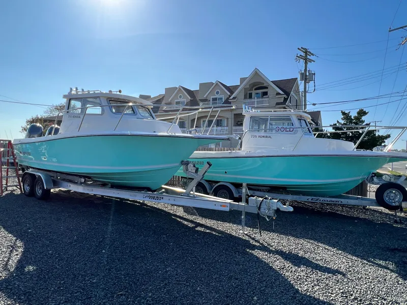 Slide: The Image of 2024 Defiance Admiral 250 EX boats on trailers in front of houses. - 8