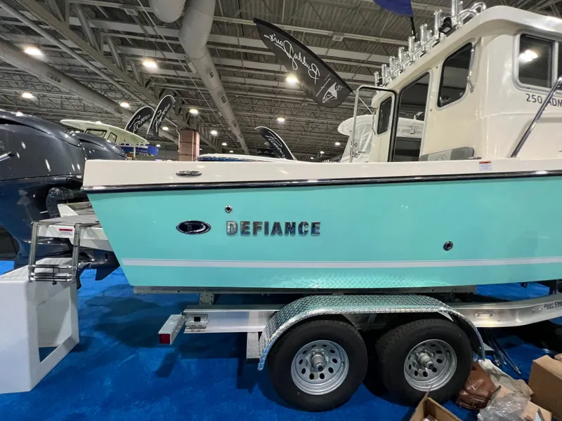 Slide: The Image of 2024 Defiance Admiral 250 EX boat on display in an indoor showroom. - 9