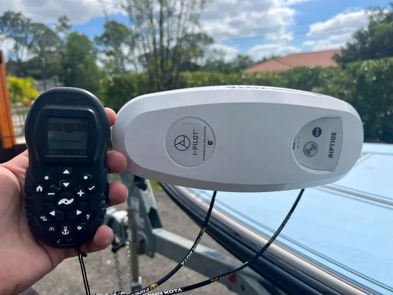 Slide: The Image of Hand holding i-Pilot remote next to Minn Kota Riptide trolling motor on 2011 Maverick 18 HPX-V boat. - 11