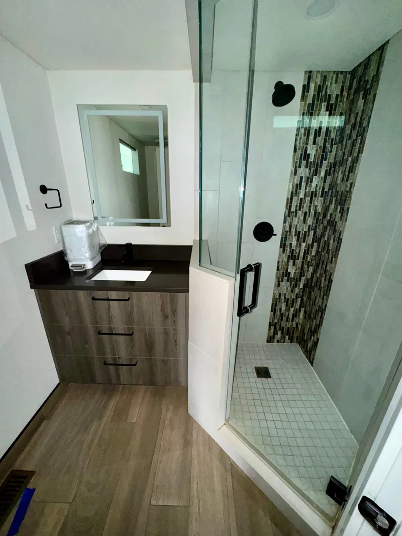 Slide: The Image of Modern bathroom in 2021 Adonia Solace Trip #10 RV with glass shower and wood accents. - 12