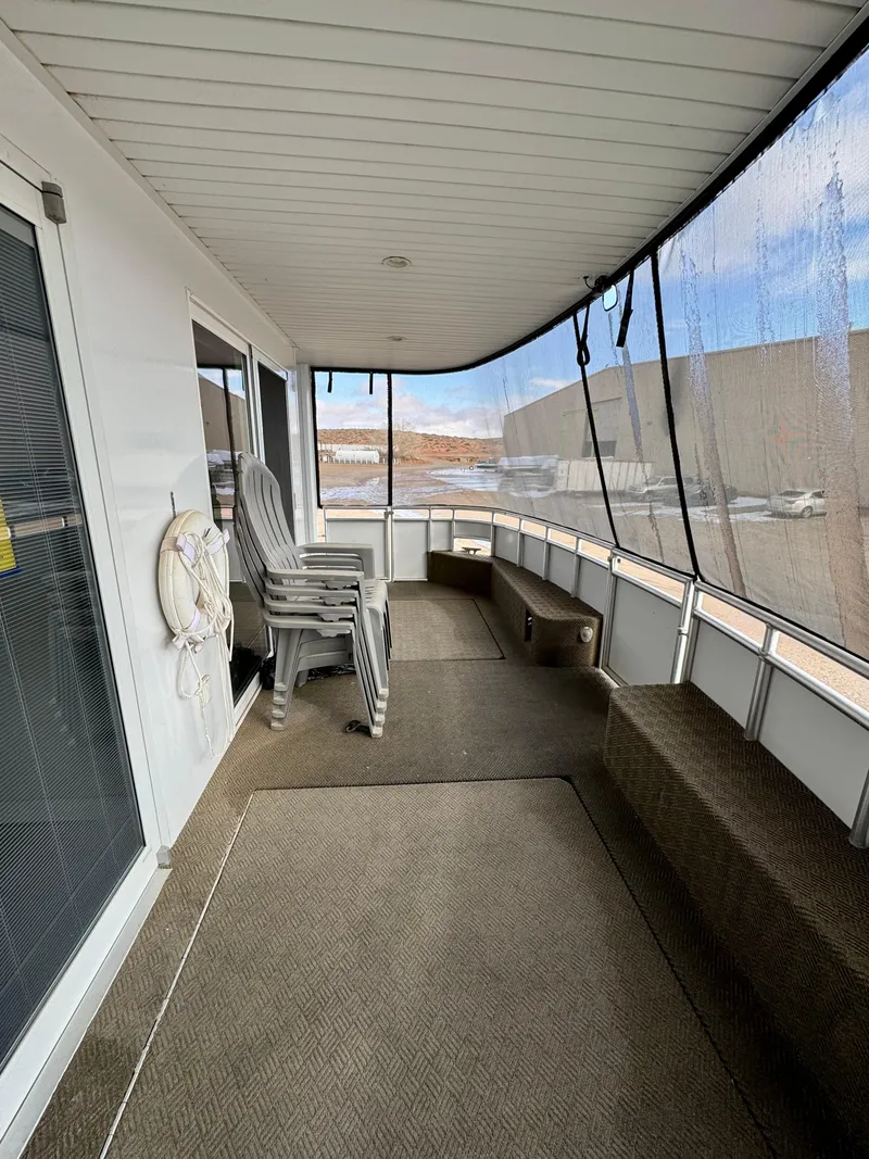 Slide: The Image of Covered deck area on Adonia Solace Trip #10 houseboat, 2021 model, with stacked chairs and lifebuoy. - 13