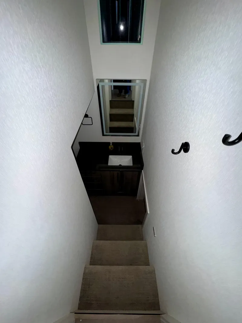 Slide: The Image of Narrow staircase in Adonia Solace Trip #10, 2021 model, with wall hooks and mirror. - 2