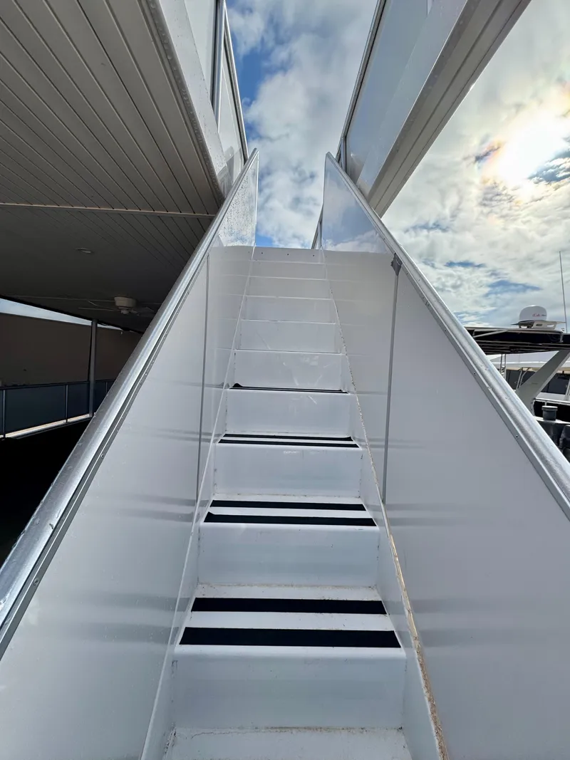 Slide: The Image of Staircase on Adonia Solace Trip #10 yacht, 2021 model, leading to upper deck under cloudy sky. - 25
