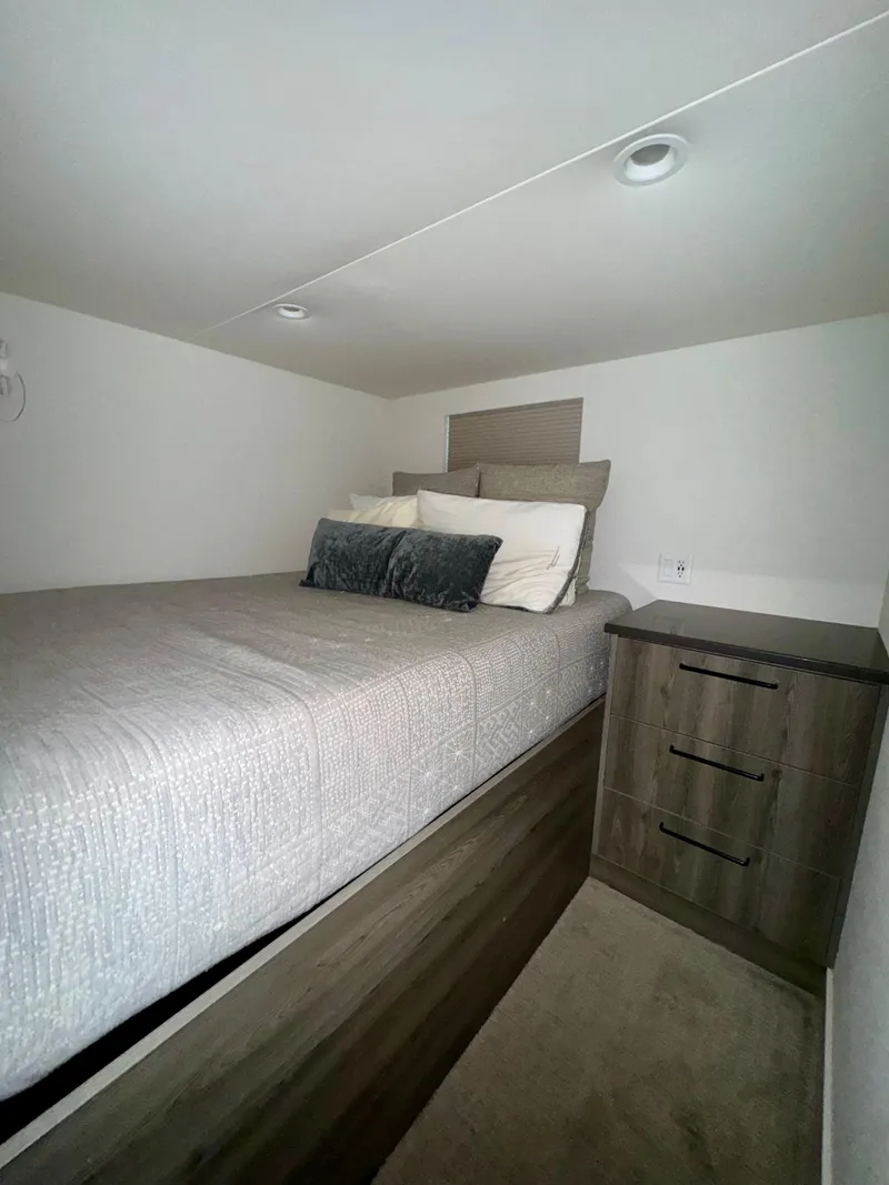 Slide: The Image of 2021 Adonia Solace Trip #10 interior with cozy bed and wooden nightstand. - 6