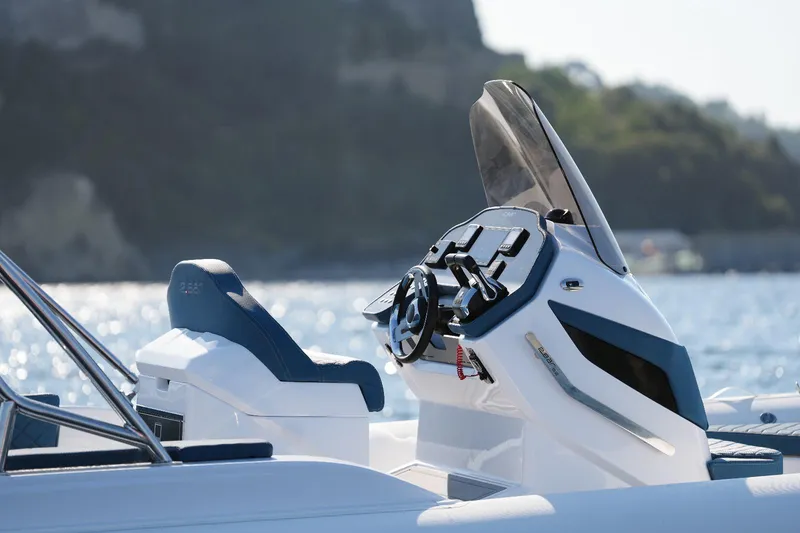 Slide: The Image of Modern 2025 2 Bar 8.2 boat dashboard and seating with scenic water background. - 12