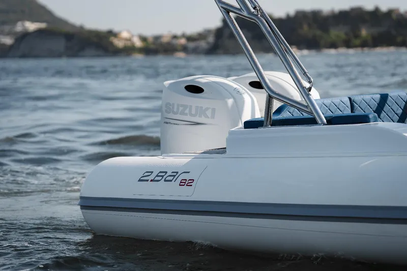 Slide: The Image of 2025 2 Bar 8.2 boat with Suzuki outboard motor on water. - 2