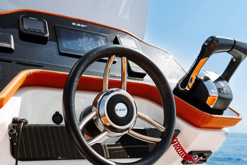 Slide: The Image of 2025 2 Bar 8.2 boat steering wheel and control panel on a sunny day. - 26