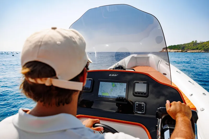 Slide: The Image of Person navigating 2025 2 Bar 8.2 boat on open water. - 32