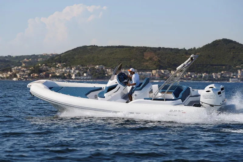 Slide: The Image of 2025 2 Bar 8.2 model boat cruising on the water with scenic hills in the background. - 8