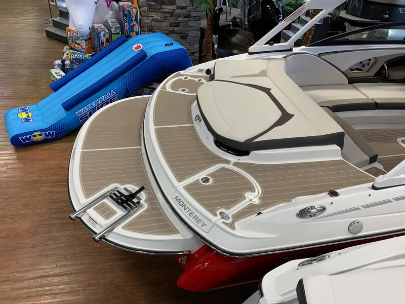 Slide: The Image of 2023 Monterey 224FS boat with swim platform and ladder, displayed indoors. - 12