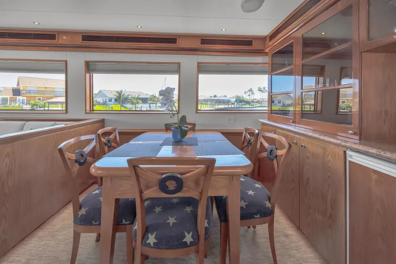 Slide: The Image of Dining area in 2001 Cheoy Lee Expedition 70 yacht with wooden furniture and star-patterned chairs. - 10