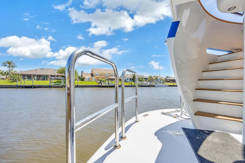 Slide: The Image of Cheoy Lee Expedition 70 yacht deck with stairs, overlooking serene waterfront view. - 28