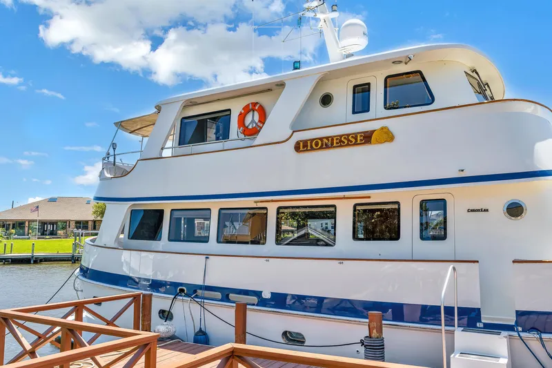 Slide: The Image of Cheoy Lee Expedition 70 yacht docked, 2001 model, named "Lionesse" under clear blue sky. - 38