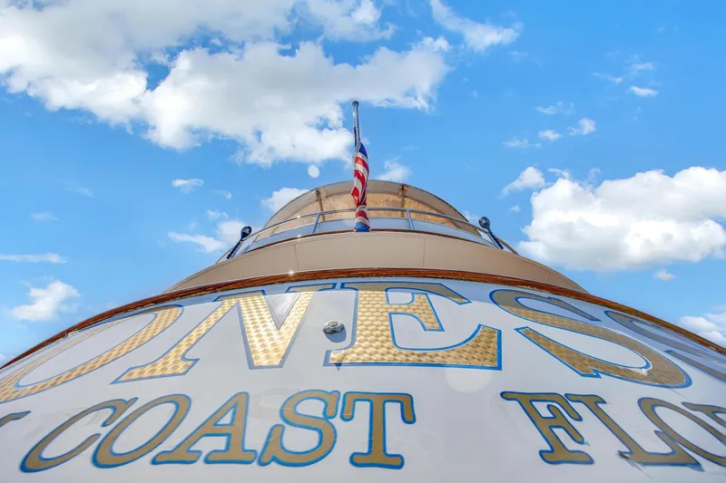 Slide: The Image of Cheoy Lee Expedition 70 yacht, 2001, with American flag against blue sky. - 40