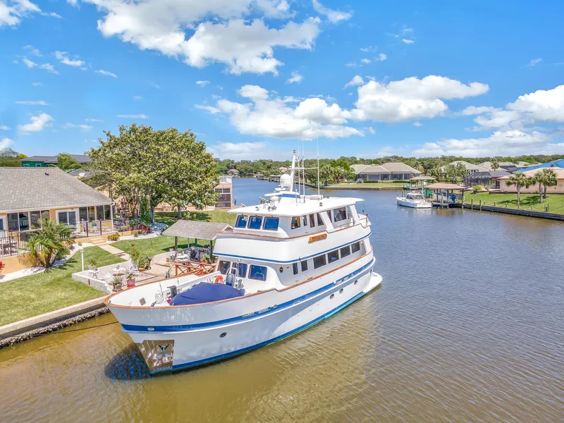 Slide: The Image of Cheoy Lee Expedition 70 yacht, 2001 model, cruising in a scenic canal under a clear blue sky. - 46