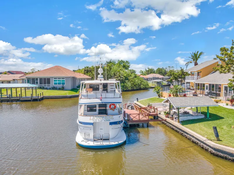 Slide: The Image of Cheoy Lee Expedition 70 yacht docked in a scenic residential canal, 2001 model. - 49