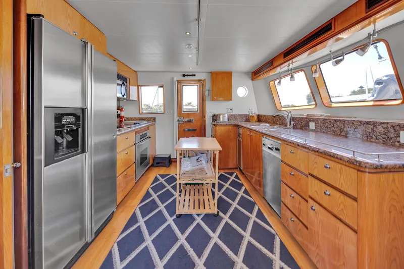 Slide: The Image of Spacious kitchen in 2001 Cheoy Lee Expedition 70 yacht with modern appliances and wooden cabinetry. - 9
