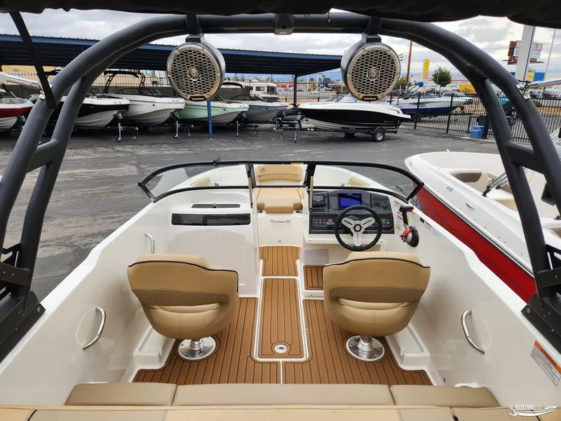 Slide: The Image of 2023 Bayliner VR4 boat interior with tan seats and modern dashboard. - 2
