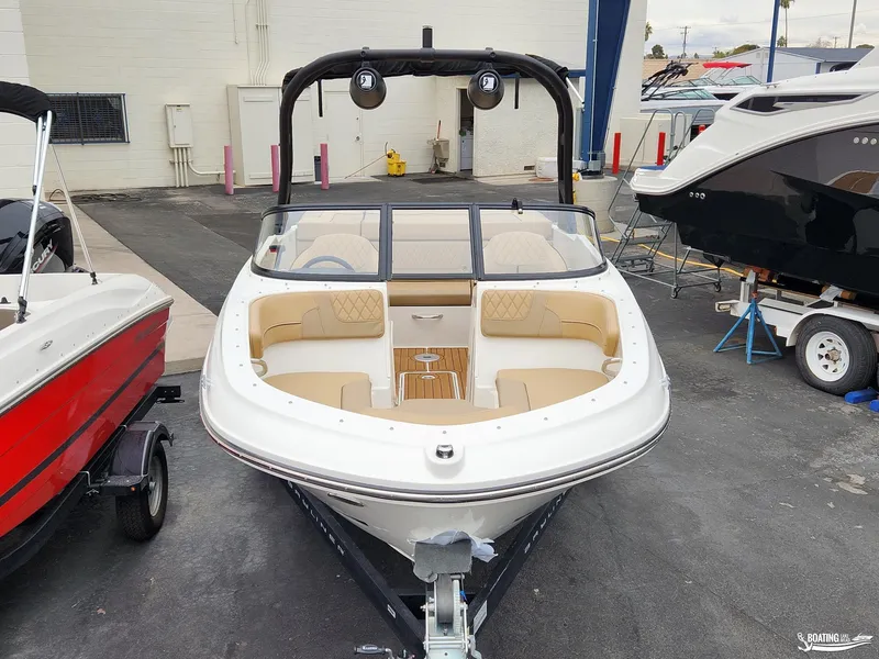 Slide: The Image of 2023 Bayliner VR4 boat with beige interior, displayed in a showroom. - 4