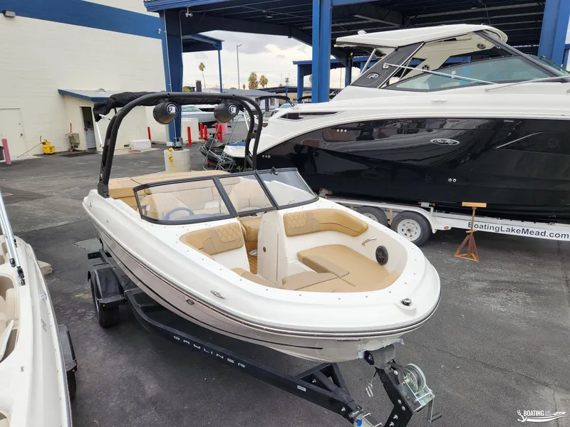 Slide: The Image of 2023 Bayliner VR4 boat on trailer at marina, featuring sleek design and spacious seating. - 5