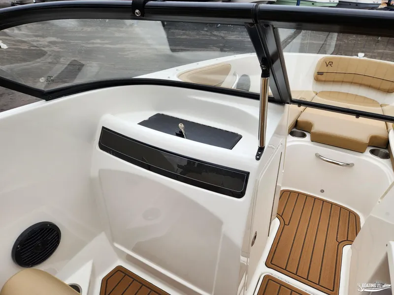 Slide: The Image of 2023 Bayliner VR4 boat interior with tan seating and wood-style flooring. - 7