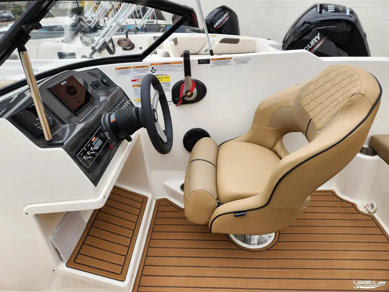 Slide: The Image of 2023 Bayliner VR4 boat interior with tan captain's chair and modern dashboard. - 8