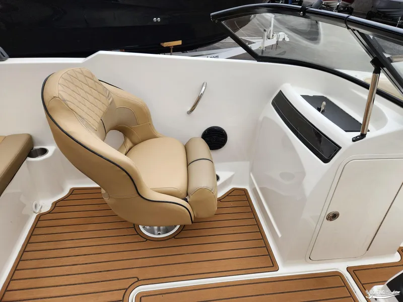Slide: The Image of 2023 Bayliner VR4 boat interior with tan captain's chair and wood-style flooring. - 9