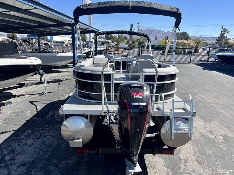 Slide: The Image of 2023 Bennington 21SXSRC pontoon boat with Mercury 115 Pro motor, parked outdoors. - 1