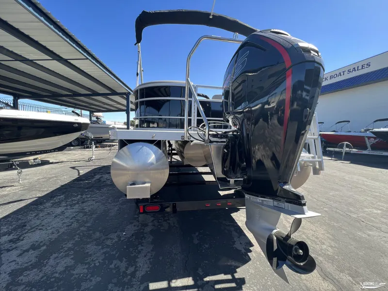 Slide: The Image of 2023 Bennington 21SXSRC pontoon boat with powerful outboard motor at dock. - 2