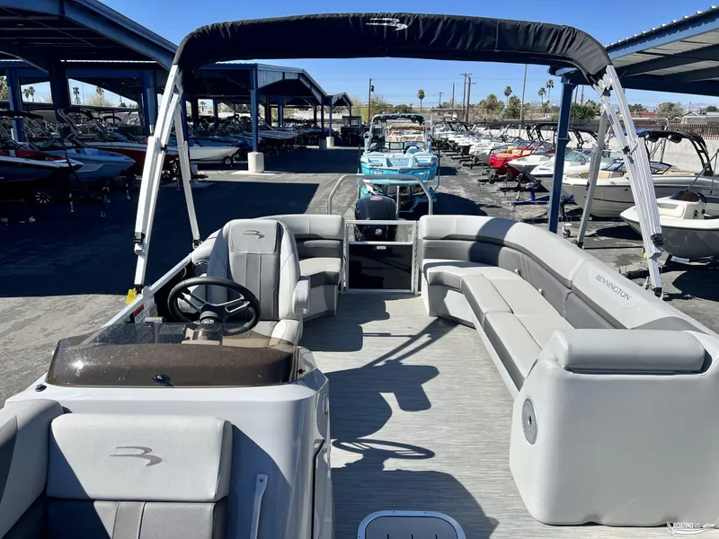 Slide: The Image of 2023 Bennington 21SXSRC pontoon boat with spacious seating and canopy in a marina setting. - 7