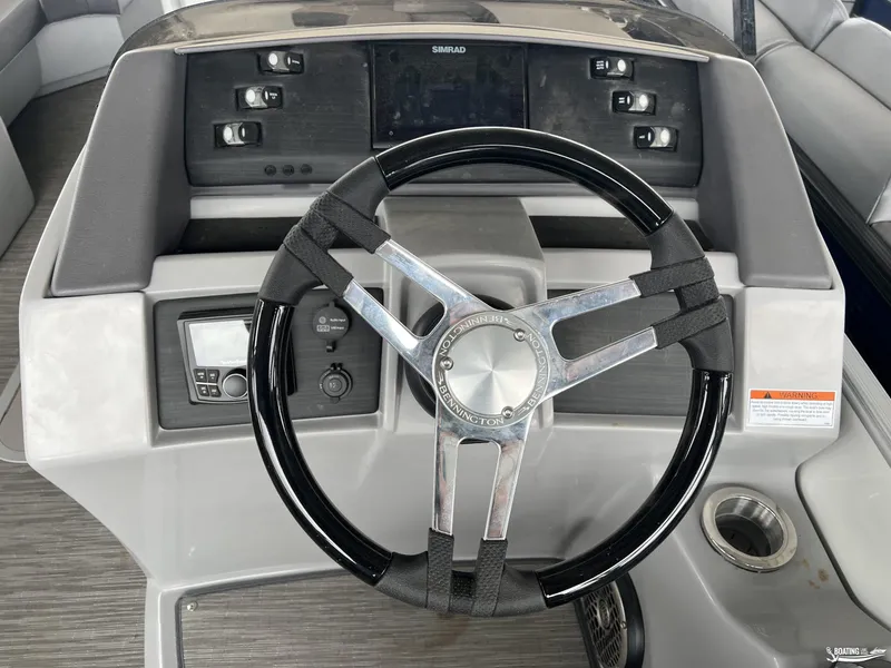 Slide: The Image of 2023 Bennington 23LSB boat dashboard with steering wheel and controls. - 11