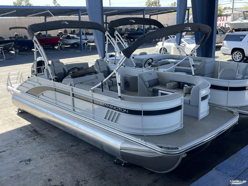 Slide: The Image of 2023 Bennington 23LSB pontoon boat with canopy, parked in a marina. - 4