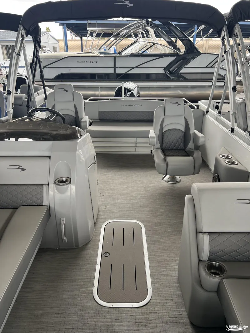 Slide: The Image of 2023 Bennington 23LSB pontoon boat interior with gray seating and helm. - 7