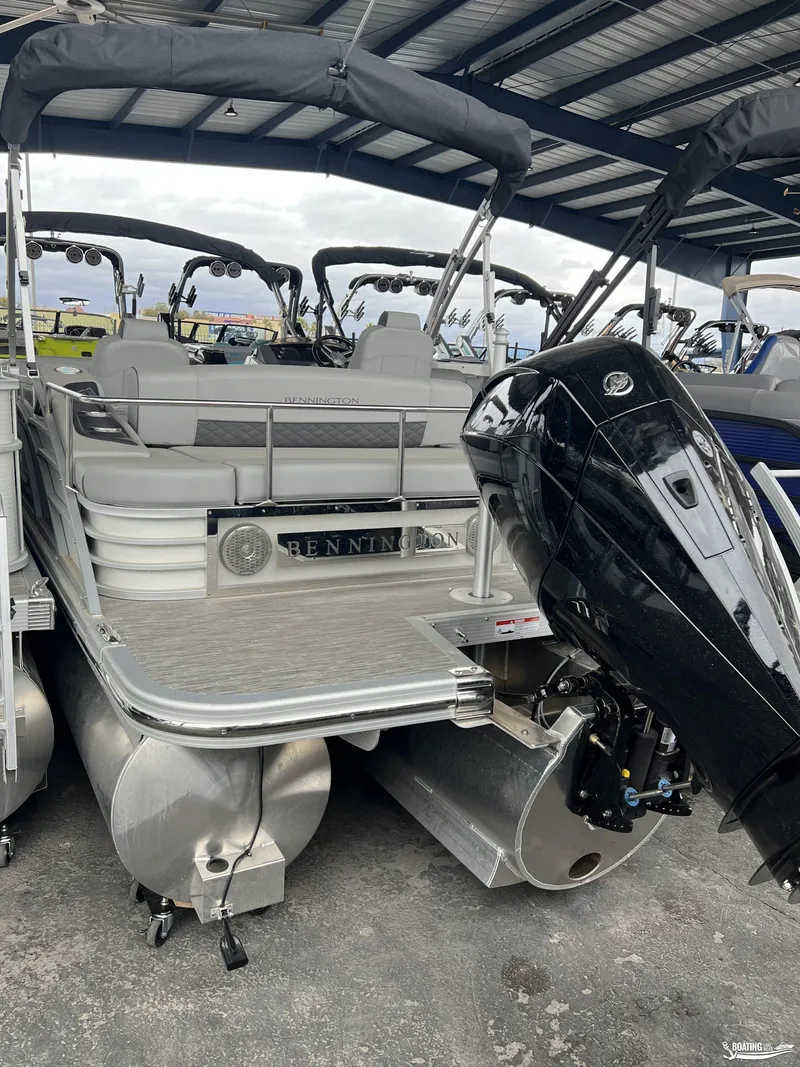 Slide: The Image of 2023 Bennington 23LSB pontoon boat with powerful outboard motor in covered storage. - 8
