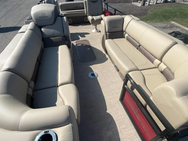 Slide: The Image of 2023 Regency 230 LE3 Sport boat interior with beige seating and carpet. - 3