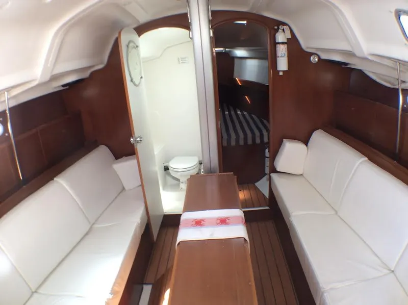 Slide: The Image of Interior of 2003 Beneteau First yacht with white seating, wooden accents, and compact bathroom. - 11