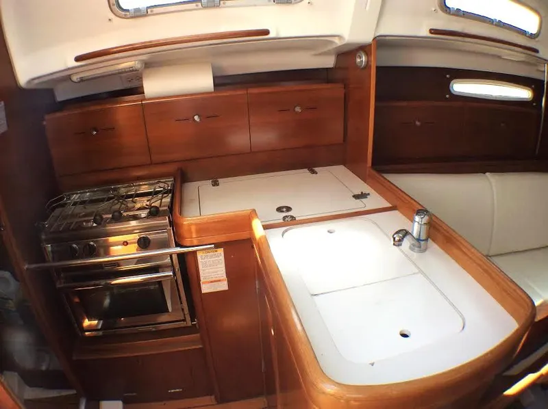Slide: The Image of 2003 Beneteau First yacht kitchen with wooden cabinetry and stainless steel appliances. - 13