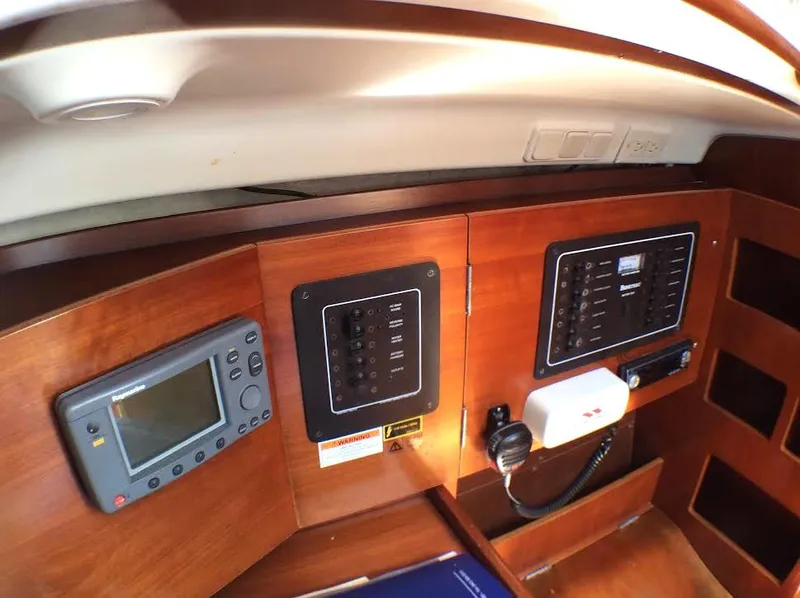 Slide: The Image of Control panel inside a 2003 Beneteau First sailboat, featuring navigation and communication equipment. - 14